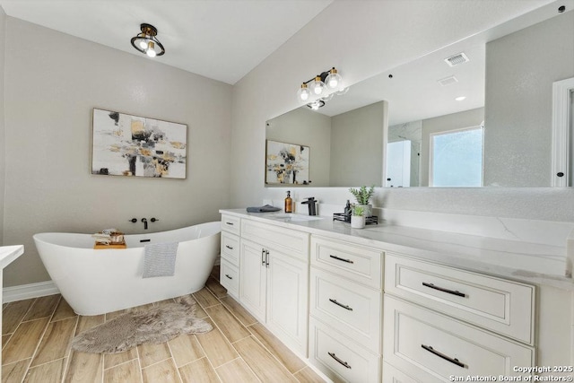 bathroom featuring vanity and a washtub