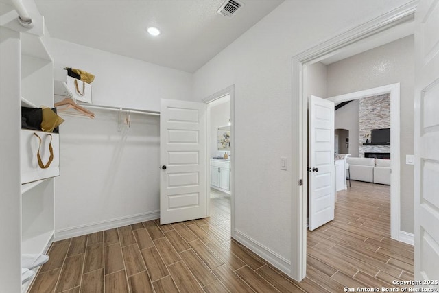 walk in closet with a stone fireplace