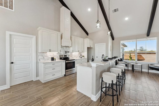 kitchen featuring stainless steel range with electric cooktop, high vaulted ceiling, white cabinets, and beamed ceiling