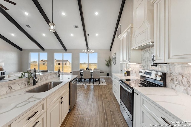 kitchen featuring stainless steel appliances, light stone counters, and hanging light fixtures