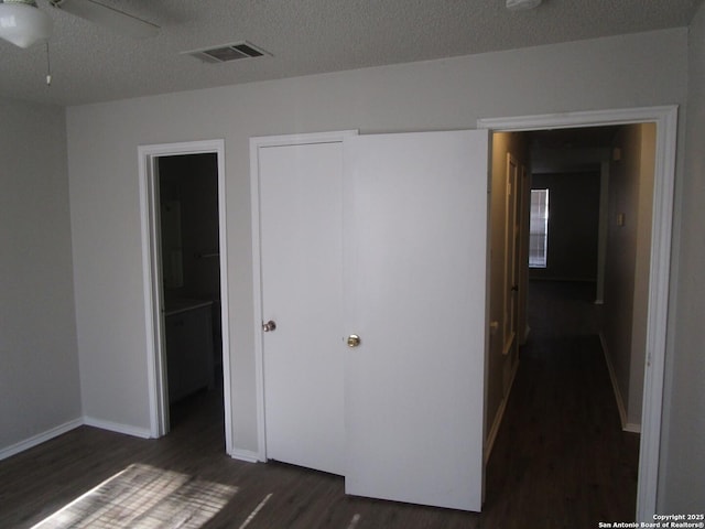 interior space featuring a textured ceiling, ceiling fan, dark hardwood / wood-style flooring, and connected bathroom