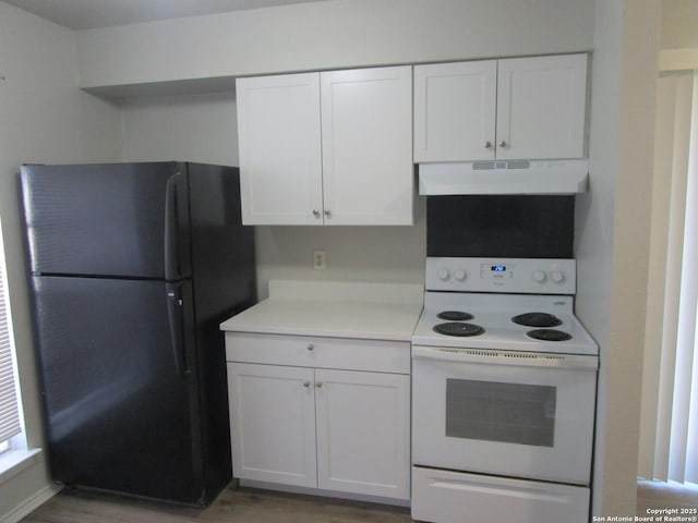 kitchen with black refrigerator, white cabinetry, electric range, and wood-type flooring