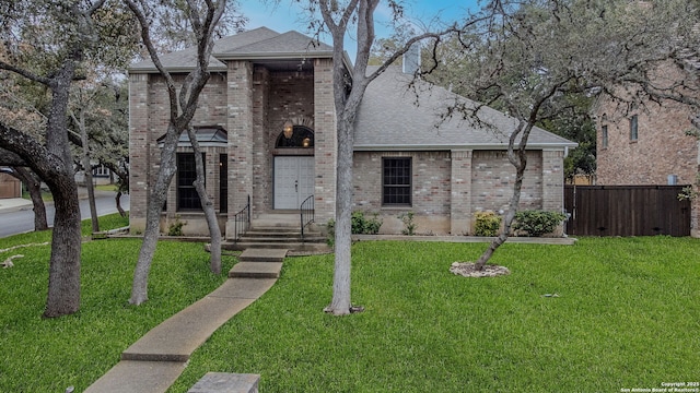 french country home with a front yard, fence, and brick siding