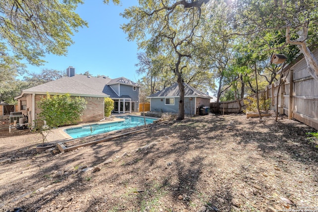 view of pool with a fenced in pool, a fenced backyard, and an outdoor structure