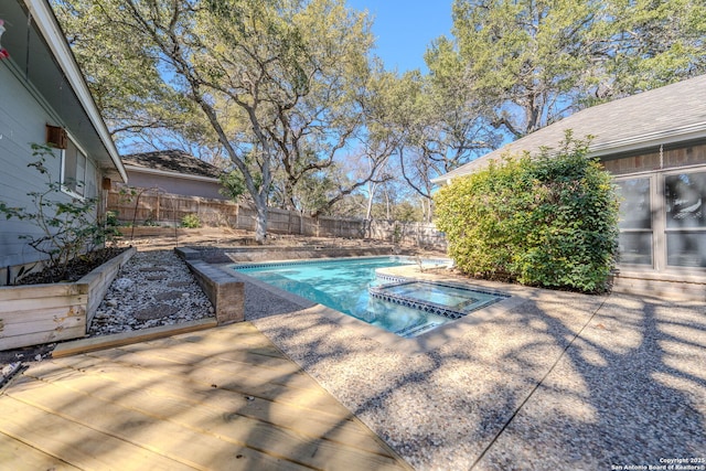 view of pool featuring a pool with connected hot tub, a patio area, a fenced backyard, and a vegetable garden