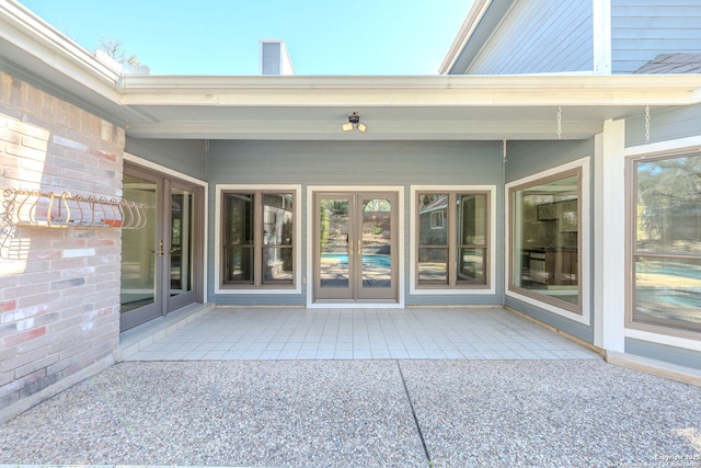 doorway to property featuring brick siding and french doors