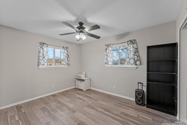 unfurnished room featuring light wood-type flooring, ceiling fan, and plenty of natural light