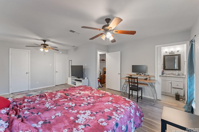 bedroom with ceiling fan, light hardwood / wood-style flooring, and connected bathroom