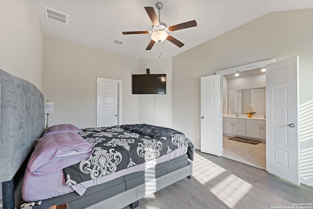 bedroom featuring ceiling fan, light hardwood / wood-style flooring, and ensuite bath