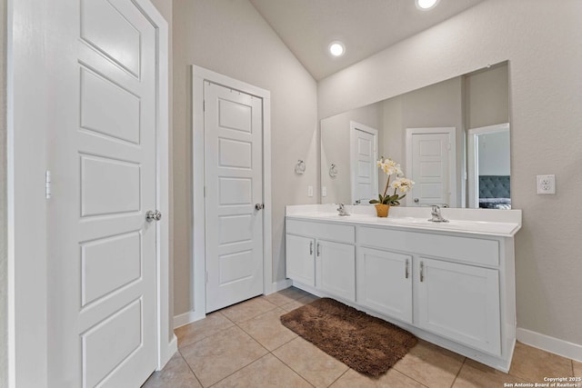 bathroom with vaulted ceiling, tile patterned floors, and vanity