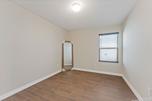 spare room featuring a textured ceiling and hardwood / wood-style floors