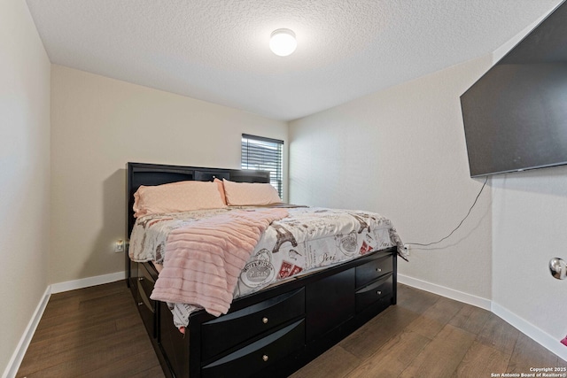 bedroom with a textured ceiling and dark hardwood / wood-style floors