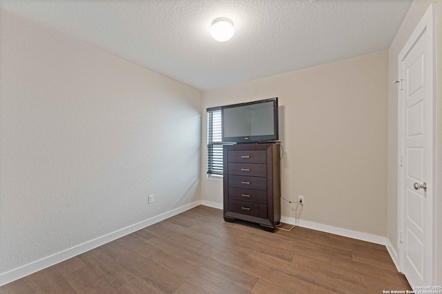 unfurnished bedroom with a textured ceiling and hardwood / wood-style flooring