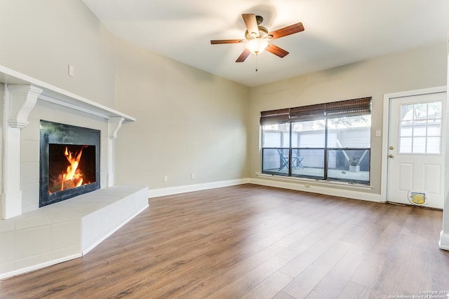 unfurnished living room featuring a fireplace, ceiling fan, and wood-type flooring