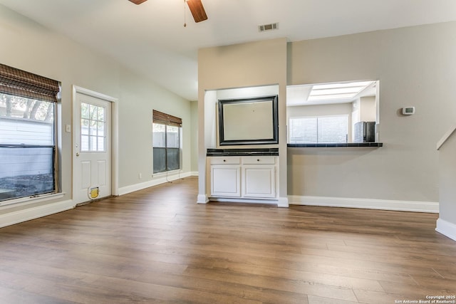 unfurnished living room featuring ceiling fan and dark hardwood / wood-style floors