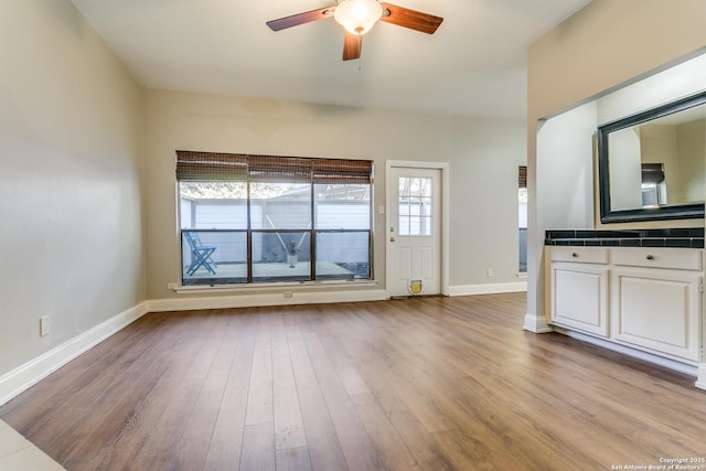 unfurnished living room with light wood-type flooring and ceiling fan