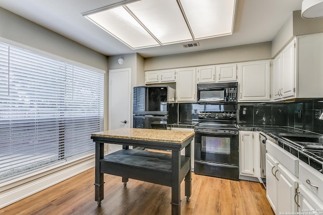 kitchen with black appliances, light wood-type flooring, white cabinets, and tasteful backsplash