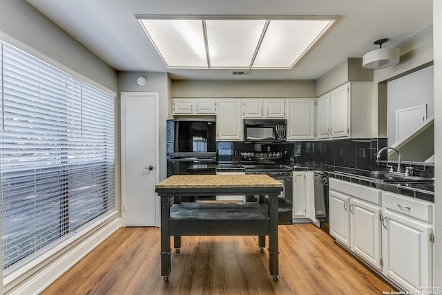 kitchen with tile counters, black appliances, decorative backsplash, white cabinets, and sink