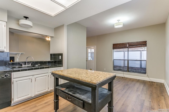 kitchen featuring sink, white cabinets, black dishwasher, ceiling fan, and light hardwood / wood-style floors