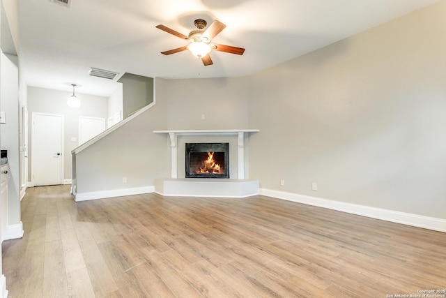 unfurnished living room featuring ceiling fan and light hardwood / wood-style flooring