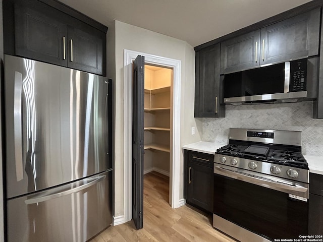 kitchen with decorative backsplash, light hardwood / wood-style floors, and appliances with stainless steel finishes