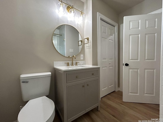 bathroom featuring wood-type flooring, vanity, and toilet