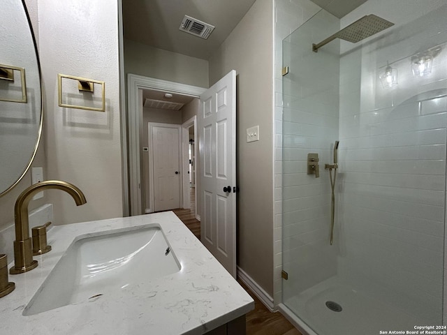 bathroom with vanity, hardwood / wood-style floors, and walk in shower