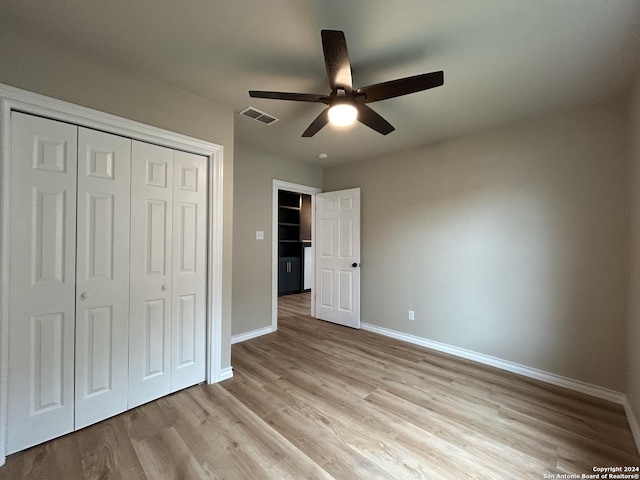 unfurnished bedroom with ceiling fan, light hardwood / wood-style flooring, and a closet