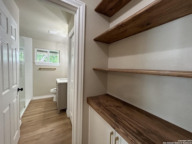 bathroom with toilet, wood-type flooring, and vanity