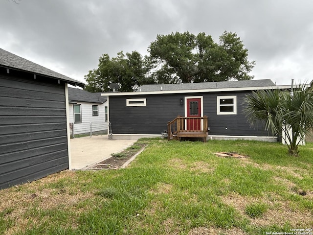 rear view of house featuring a lawn and a patio area