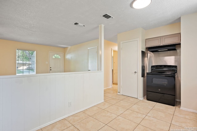 kitchen featuring gray cabinetry, wooden walls, black electric range oven, and light tile patterned floors