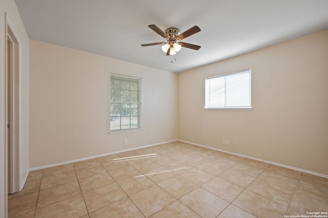 tiled spare room featuring ceiling fan