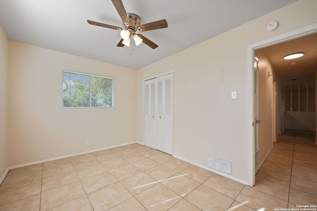 unfurnished bedroom featuring a closet, ceiling fan, and light tile patterned floors