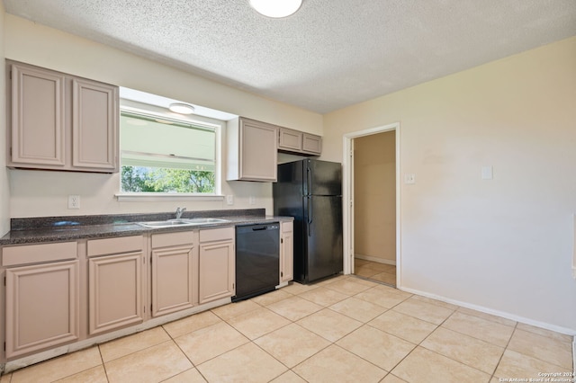 kitchen featuring sink, light tile patterned floors, a textured ceiling, and black appliances