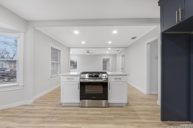 kitchen with ceiling fan, light hardwood / wood-style flooring, white cabinetry, and stainless steel range with gas cooktop