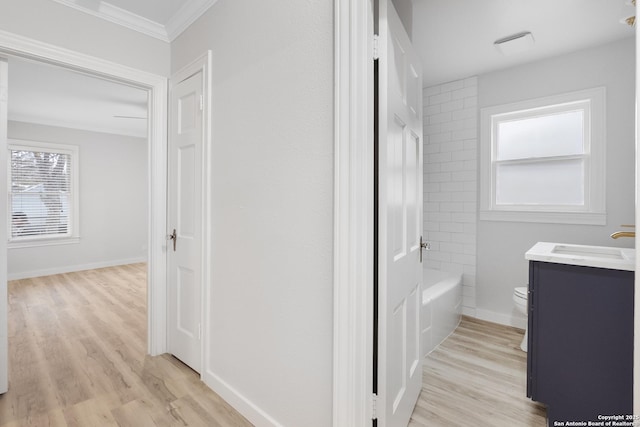 full bathroom featuring toilet, crown molding, vanity, and hardwood / wood-style flooring