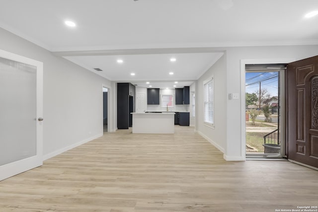 unfurnished living room featuring light wood-type flooring and crown molding