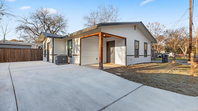 view of front of home with central AC unit and a garage