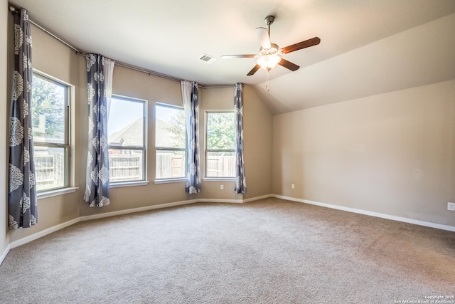 additional living space featuring ceiling fan, vaulted ceiling, carpet floors, and plenty of natural light