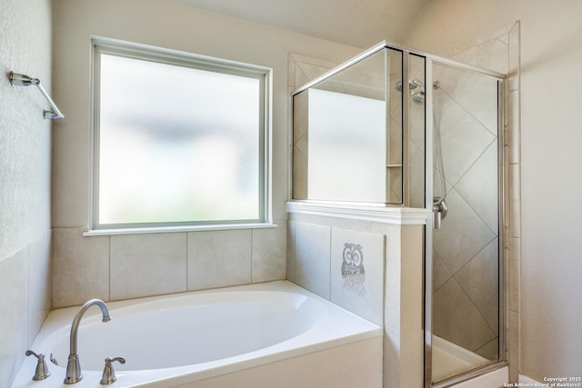 bathroom featuring shower with separate bathtub