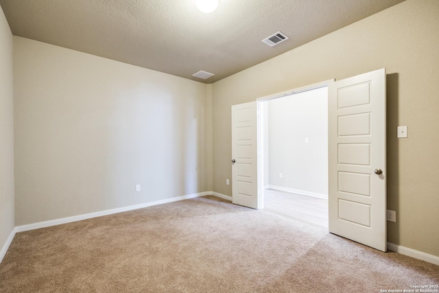 carpeted spare room featuring a textured ceiling