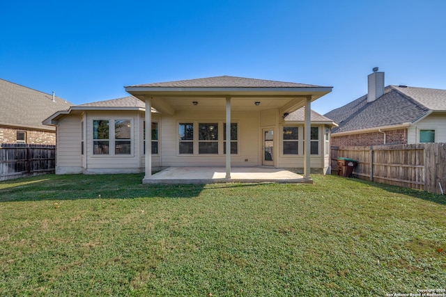 rear view of house featuring a lawn and a patio area