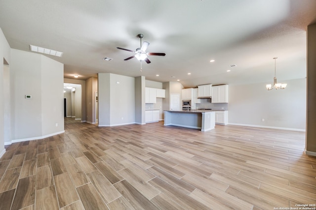 unfurnished living room with light hardwood / wood-style floors and ceiling fan with notable chandelier