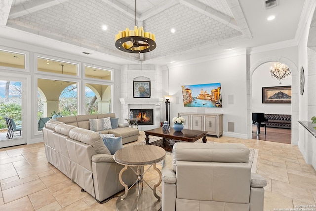 living room featuring an inviting chandelier, a large fireplace, a high ceiling, a tray ceiling, and crown molding