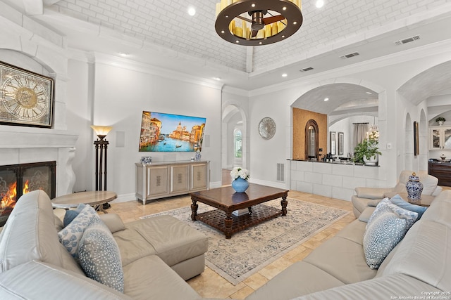 tiled living room featuring a towering ceiling and crown molding