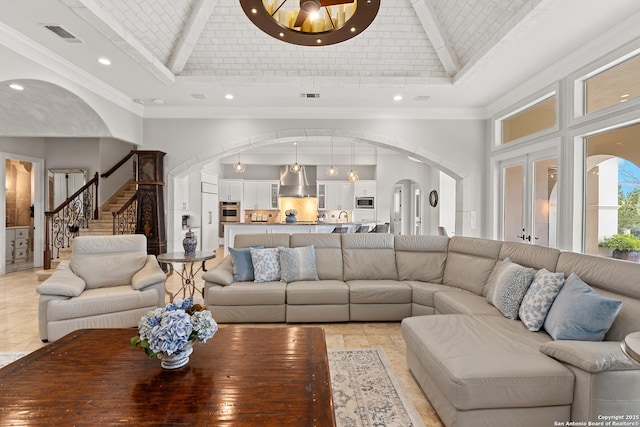 living room with sink, high vaulted ceiling, crown molding, and brick ceiling