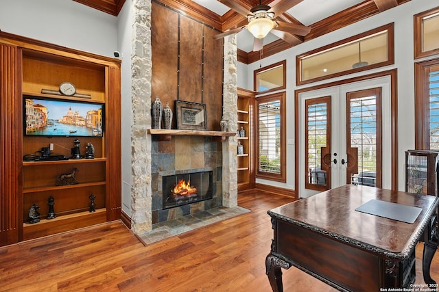 home office featuring french doors, a fireplace, hardwood / wood-style flooring, and built in features