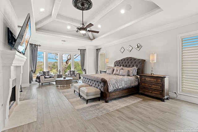 bedroom with a raised ceiling, ceiling fan, crown molding, and light hardwood / wood-style floors