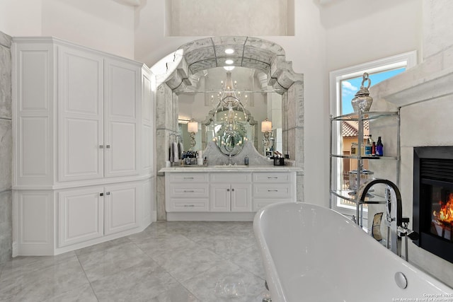 bathroom with a high ceiling, a tub to relax in, and vanity