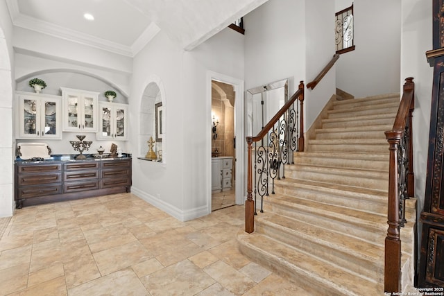 foyer with bar area and crown molding